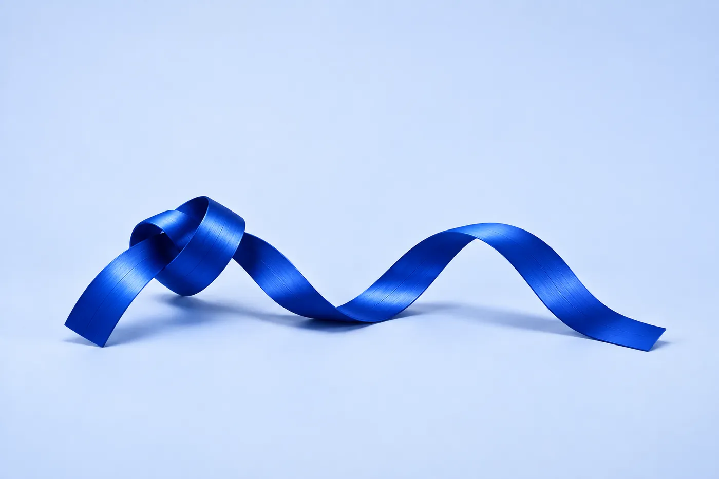 A cobalt ribbon tied in a loose knot, flowing into a smooth wave.
