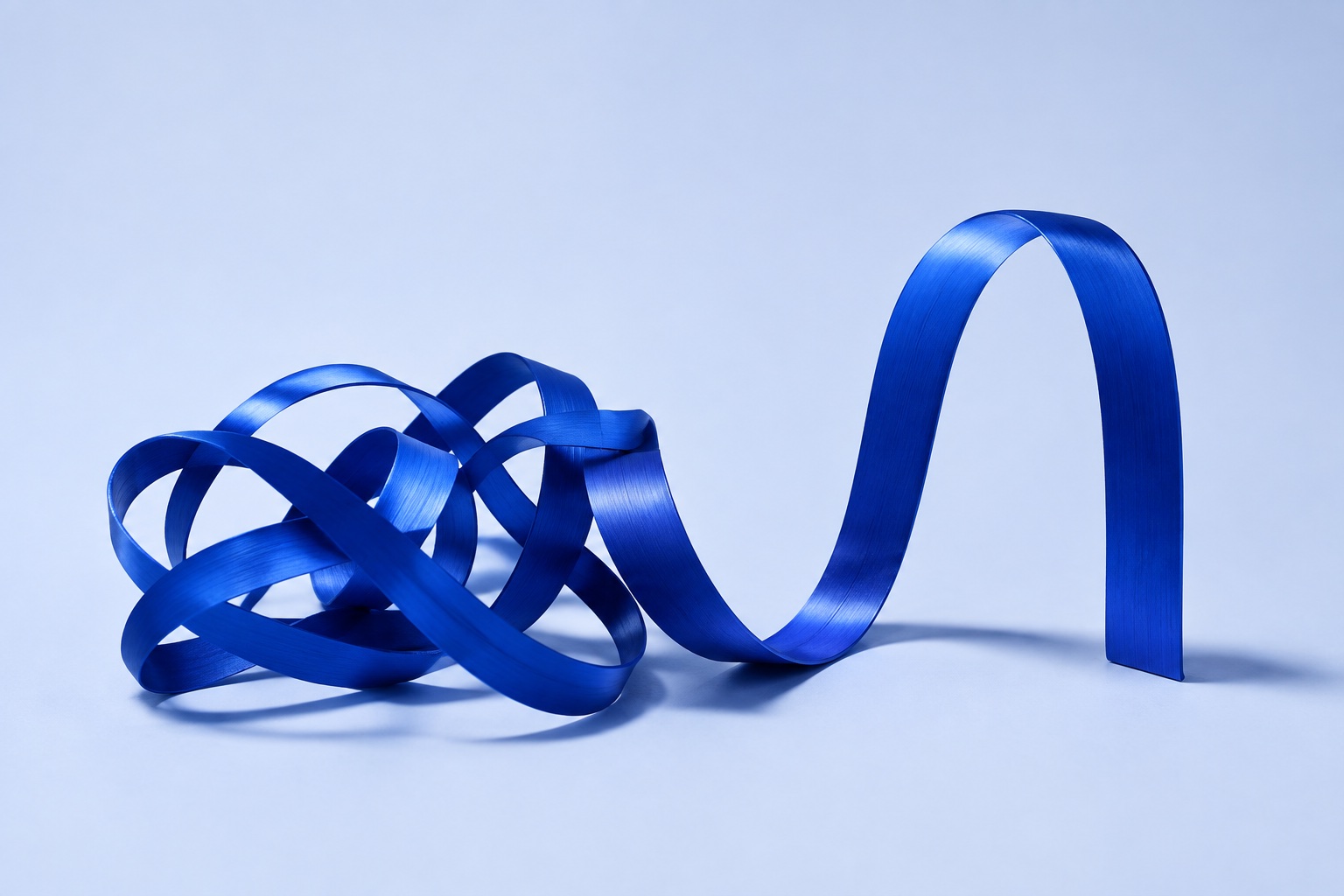 A blue ribbon moves from a loose tangle into a purposeful arch.